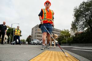 George Basioli, of Edmonds, who is blind, demonstrates the neccessity of exact standards for sidewalks , curbs, crosswalks, bus stops and more Friday in downtown Everett. (Dan Bates / The Herald)