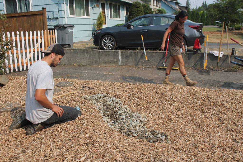 Crew members Seth Cavin and Sara Rocero work on a rain garden in Bothell on Aug. 13. (Katie Metzger / Bothell-Kenmore Reporter)
