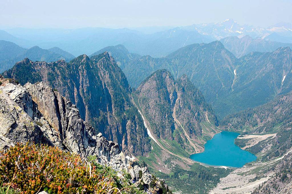 The azure-colored Copper Lake sits in a hazy bowl north of Vesper Peak, between Little Chief (at left), and Big Four Mountain, not pictured. (Caleb Hutton / Herald file)