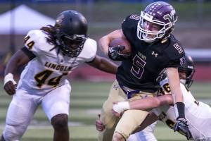 Lake Stevens Tom Lewis is tackled by Lincolns Troy Atkin with Lincolns Janoah Thomas (left) closing Friday at Lake Stevens High School. (Kevin Clark / The Herald)