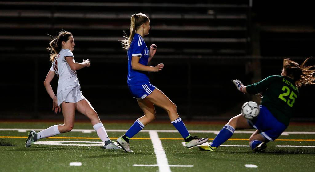 Archbishop Murphys Lexie Klaudt (left) knocks a shot past Liberty goalkeeper Taylor Thatcher (right) for a goal in the second half of the 2A state semifinal game Friday, Nov. 18, 2017, at Shoreline Stadium. Klaudt is expected to lead the Wildcats this season. (Ian Terry / Herald file)