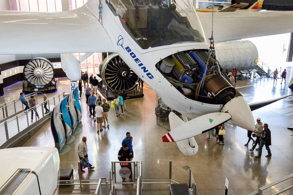 An experimental Boeing plane hangs as visitors look at engines and planes on display at the Future of Flight Aviation Center and Boeing Tour in Mukilteo. About 500,000 people visited the center in 2017. (Andy Bronson / The Herald)