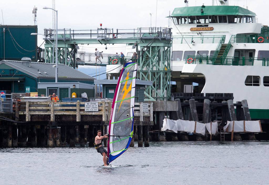 Waiting for the next ferry to come in, Hayden Potter gets in a short sailboard run along the beach at the Edmonds Ferry dock on Friday, Sept. 21, 2018 in Edmonds, Wa. (Andy Bronson / The Herald)