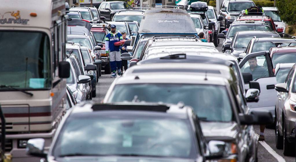 Passengers head to their car after picking up food while waiting lines for a ferry at the Edmonds Ferry dock on Friday, Sept. 21, 2018 in Edmonds, Wa. (Andy Bronson / The Herald)