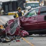 A Snohomish County firefighter stands next to a vehicle involved in a crash on I-5 southbound north of the Highway 530 interchange on Sept. 16, 2018 in Arlington, Wa. (Olivia Vanni / The Herald)