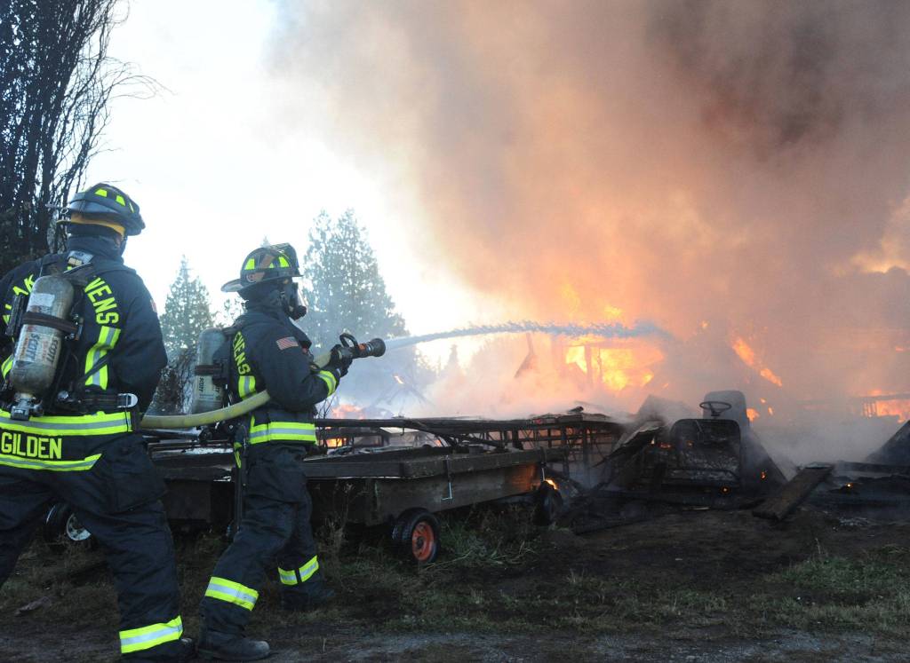 Lake Stevens firefighters attack a fire that destroyed a large outbuilding on the Fobes Road west of Snohomish on Monday night. (Doug Ramsay for The Herald)