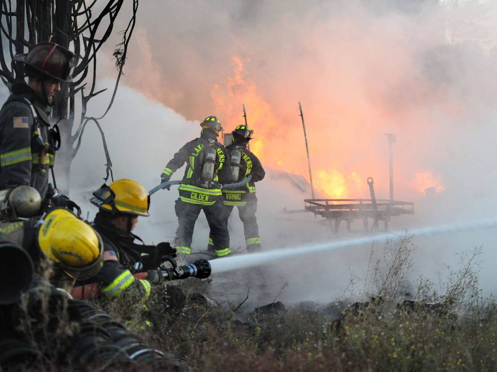 Firefighters from Snohomish, Lake Stevens and Everett assist at a fire that destroyed a large out building on Fobes Road west of Snohomish on Monday night. (Doug Ramsay for The Herald)