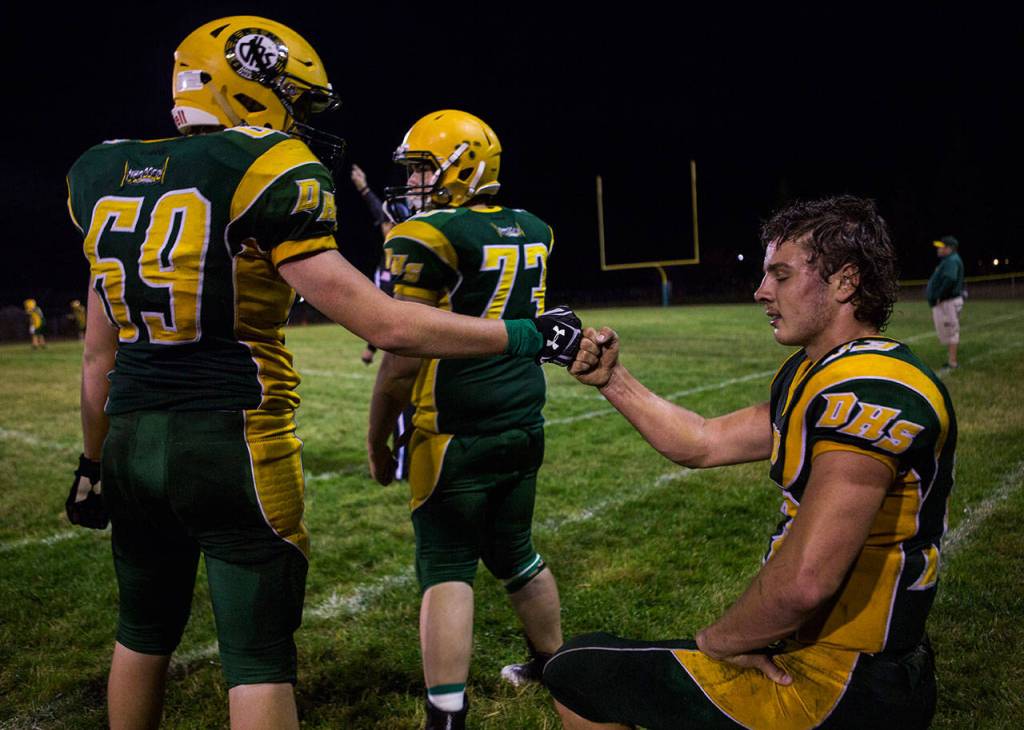 Darringtons Landen Brown fist-bumps teammate Lucas Reuwsaat during the Loggers 44-0 win over Evergreen Lutheran on Sept. 14 in Darrington. (Olivia Vanni / The Herald)