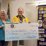 Lynnwood Food Bank Director Alissa Jones receives $2,000 from Lynnwood Kiwanis President Harvey Smith. (Contributed photo)