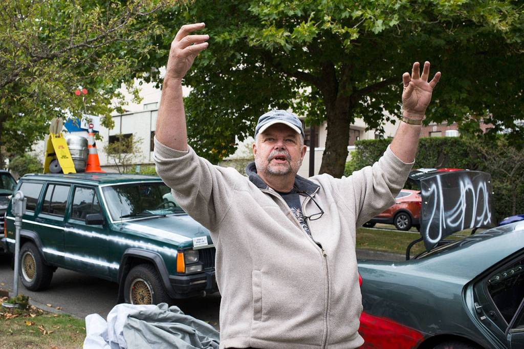 By his two vandalized cars, Chuck Johnston describes how burglars unscrewed lights in his yard, while burglarizing his home as he and his wife were sleeping. (Andy Bronson / The Herald)