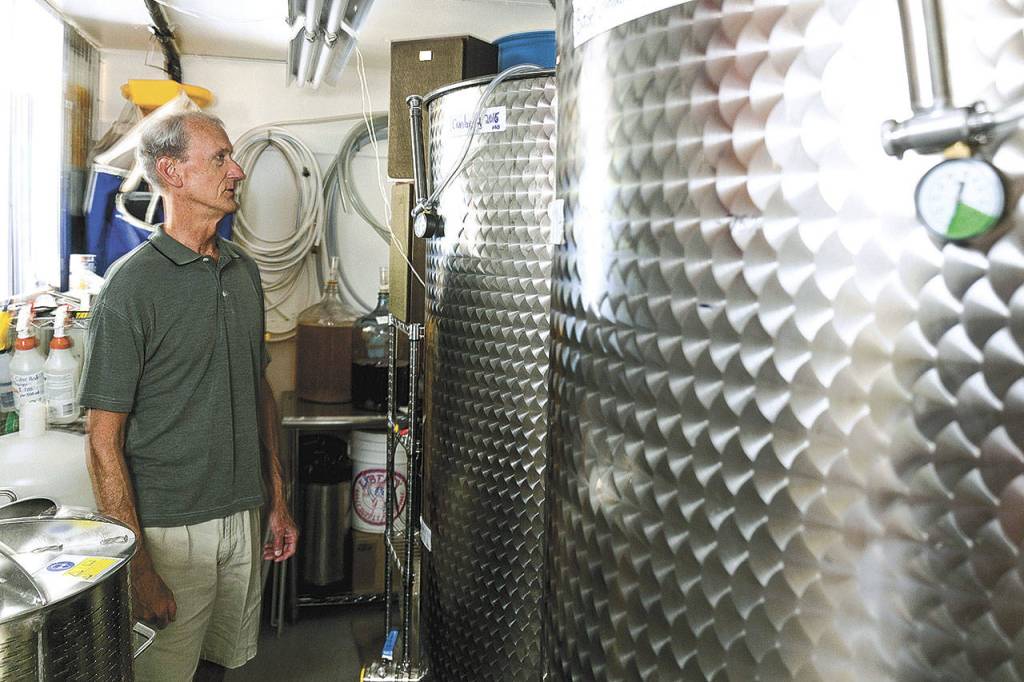 Steve Kaiser shows off the vats he uses to produce Core Hero Hard Cider out of his garage in Edmonds. (Kevin Clark / The Herald)