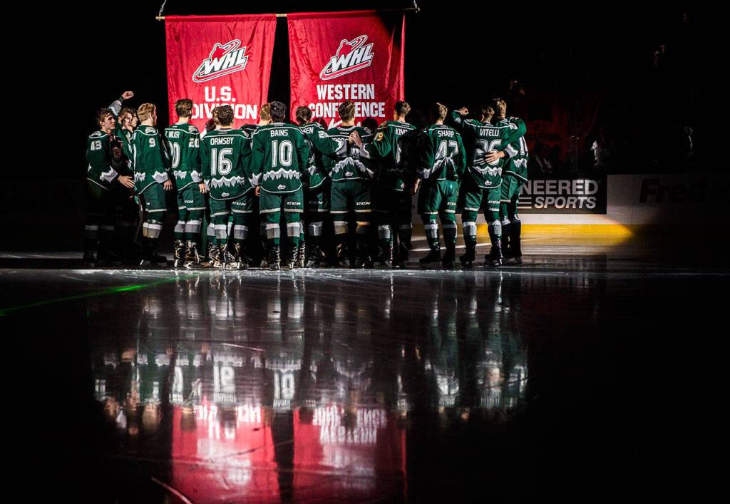 Everett players gather to raise 2017-18 Western Hockey League U.S. Division and Western Conference banners before Saturdays game at Angel of the Winds Arena. (Olivia Vanni / The Herald)