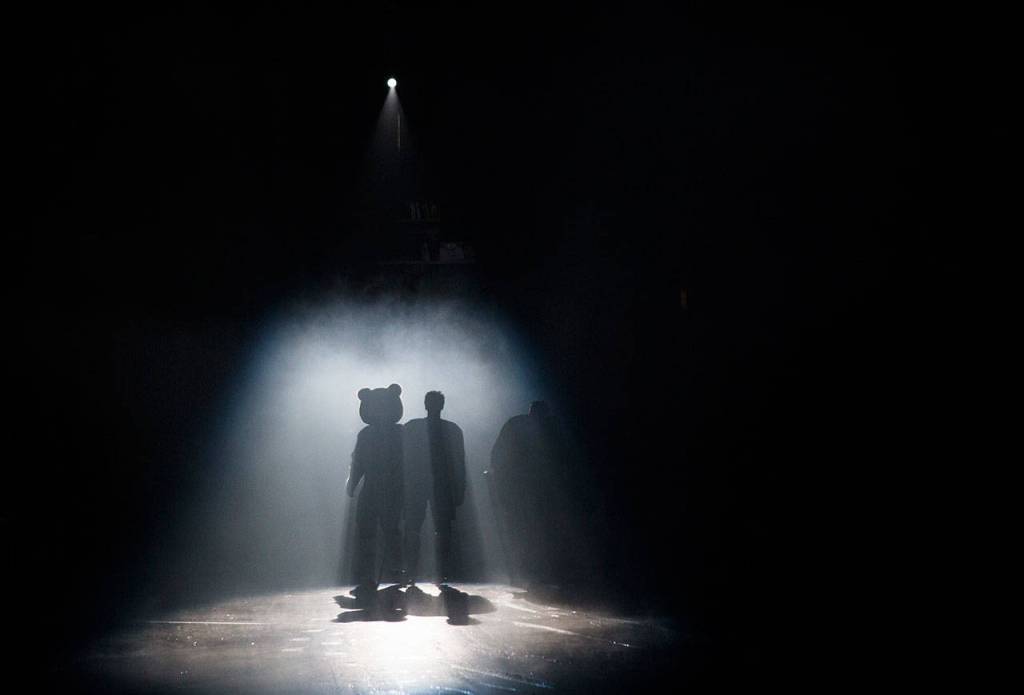 An Everett player and mascot Lincoln are silhouetted before the start of Saturdays game at Angel of the Winds Arena. (Olivia Vanni / The Herald)