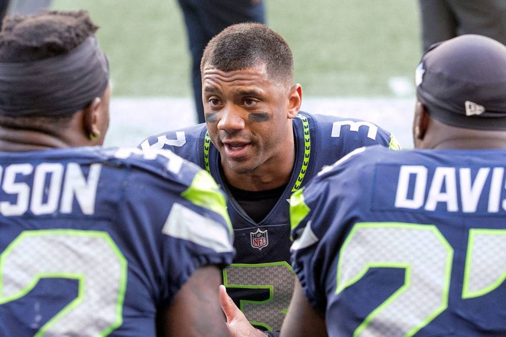 Seahawks Russell Wilson talks with running backs Chris Carson (left) and Mike Davis Sunday afternoon at CenturyLink Field in Seattle on September 23, 2018. Seahawks won 24-13. (Kevin Clark / The Herald)
