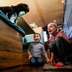Caleb, 4, joins his sister Felicity, 7, trying to coax Trusty to jump down from the seating at their boats kitchen table. (Dan Bates / The Herald)