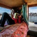 On her cozy bed overlooking the Everett Marina, the Everett Yacht Club and boats of all kinds, Arianna reads a Nancy Drew book, The Mystery at Lilac Inn. (Dan Bates / The Herald)