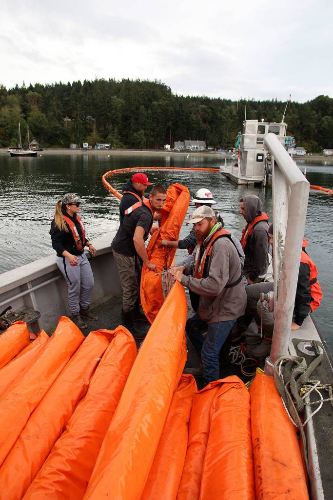 Natalie Wagoner (from left), Jay Dassow, Jeremiah Tumulty and Brandon Andrews help National Response Corporation deckhand Tyler Millius retrieve an oil boom during a training exercise on Sept. 21. (Laura Guido / Whidbey News-Times)