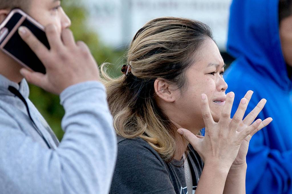 A family member arrives at the scene of a two-car accident on the 7100 block of Evergreen Way on Wednesday afternoon in Everett. (Kevin Clark / The Herald)