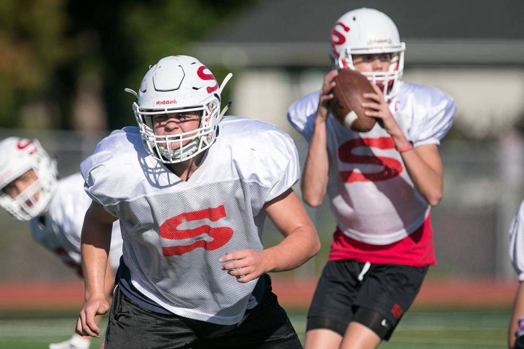 Snohomishs Joel Bowlin (left) looks to block as teammate Tayte Conover (right) looks to pass during a Thursday practice session at Veterans Memorial Stadium (Kevin Clark / The Herald)