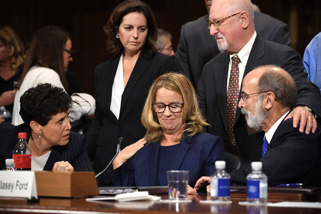 Christine Blasey Ford takes a break in her testimony before the Senate Judiciary Committee on Thursday on Capitol Hill in Washington. Lawyers seated are Debra Katz and Michael Bromwich. (Saul Loeb/ Pool Image via AP)