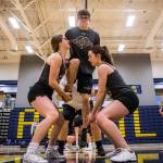 Skyler LaPointe (left) and Haley Prather (right) lift Ryan Sphung during rehearsal in the Everett High School gym on Sept. 26. (Olivia Vanni / The Herald)