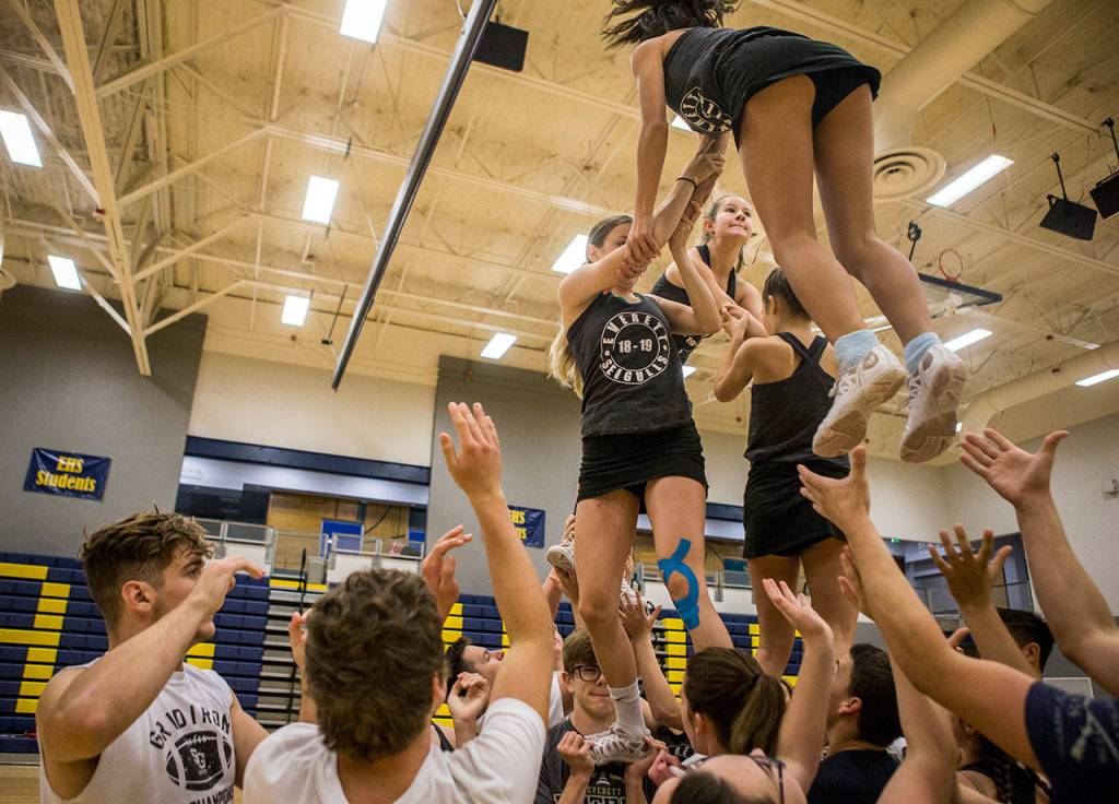 Everett High School cheerleaders and football players work together during rehearsal in the Everett High School gym on Sept. 26. (Olivia Vanni / The Herald)