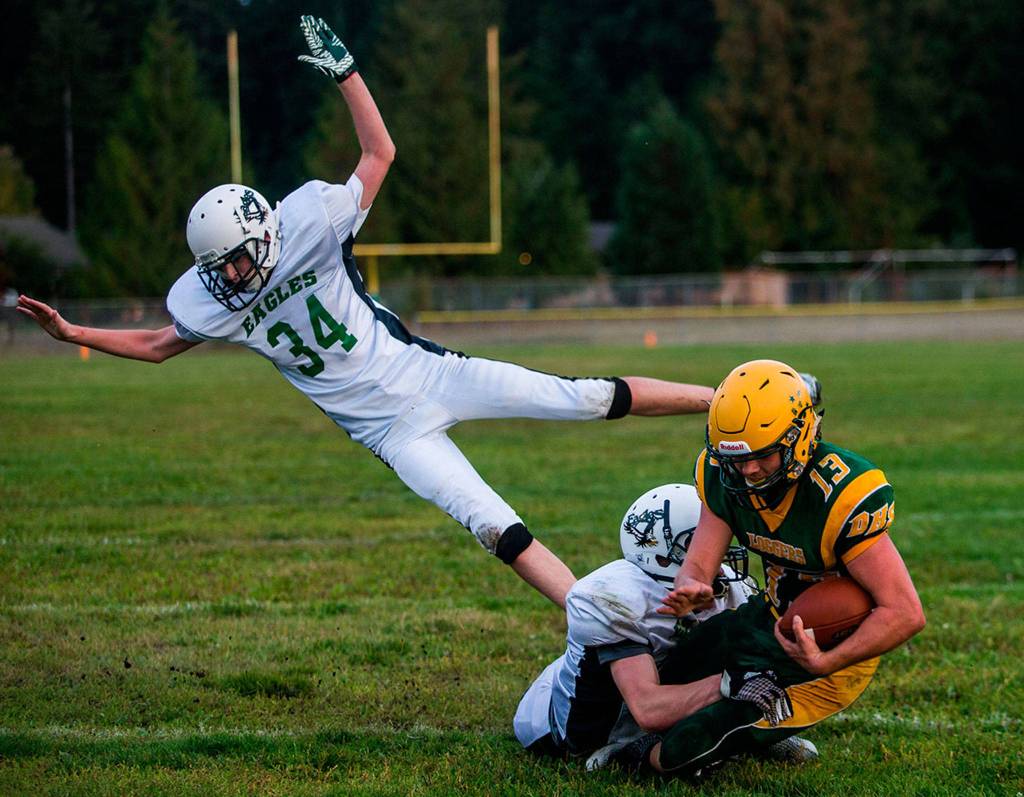 Evergreen Lutherans Gabe Lorette jumps to avoid the tackle of Darringtons Lucas Reuwsaat after his touchdown to during the game on Sept. 14 in Darrington. (Olivia Vanni / The Herald)