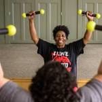 Darliene Ifiorah, 55, leads a student in exercises during a Zumba class at the Stillaguamish Senior Center in Arlington. (Olivia Vanni / The Herald)