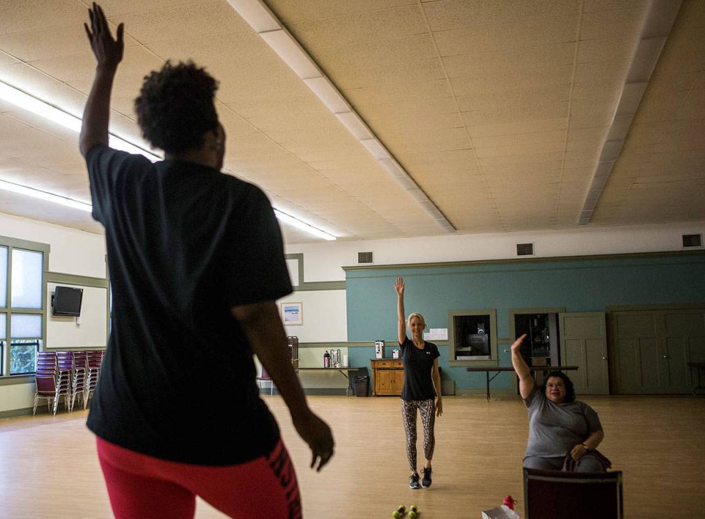 Teresa Klein, center, and Suzie Coar, right, mirror Darliene Ifiorahs exercise motions during a class at the Stillaguamish Senior Center in Arlington. (Olivia Vanni / The Herald)