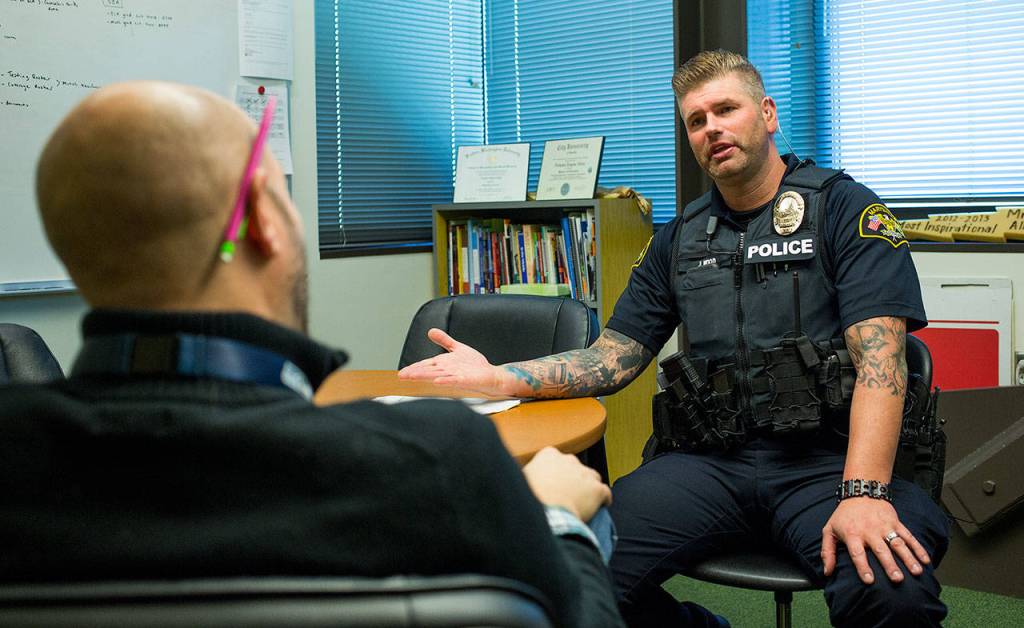 School Resource Officer Jeremy Wood talks with Assistant Principal Nicholas Allen about a trespassing situation with a non-student on campus at Marysville Getchell High on Thursday. (Andy Bronson / The Herald)