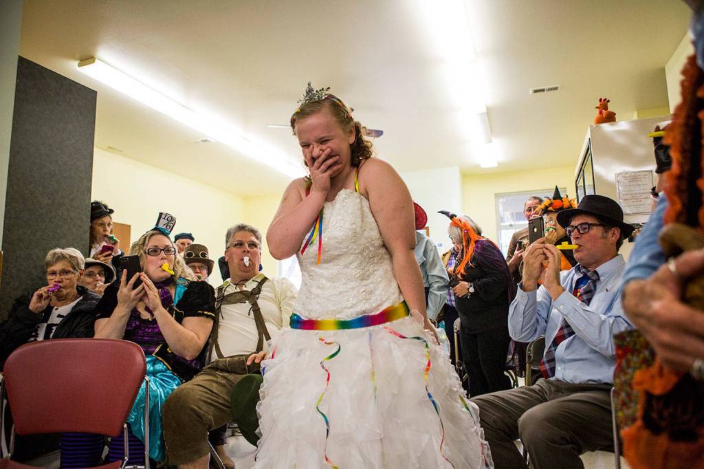 Kira Day smiles and laughs as she walks down the aisle to kazoo-rendition of Here Comes the Bride during her Halloween-themed wedding Saturday, Oct. 27, at the Snohomish Community Food Bank in Snohomish. (Olivia Vanni / The Herald)