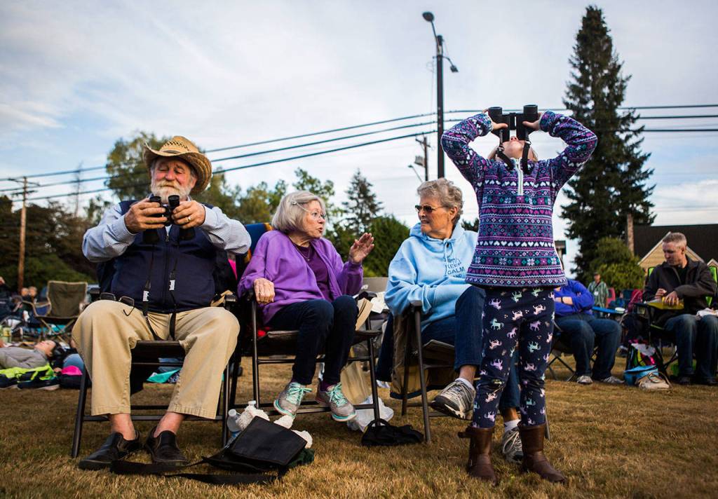 Anabelle Parsons, 6, left, looks up to the sky with binoculars to watch the Vaux Swift fly in during Swift Night Out on Sept. 8, 2018 in Monroe, Wa. Olivia Vanni / The Herald)