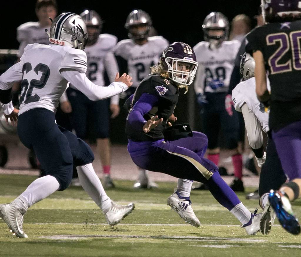 Lake Stevens Trey Long is chased out of the pocket by Glacier Peaks Mitchell Harper Friday night at Lake Stevens High School on October 5, 2018. (Kevin Clark / The Herald)