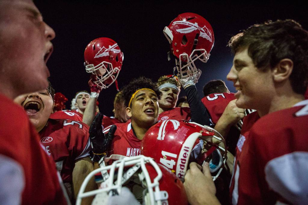 Marysville Pilchuck players cheer after winning the Berry Bowl trophy after beating Marysville-Getchell on Oct. 5 in Marysville. (Olivia Vanni / The Herald)