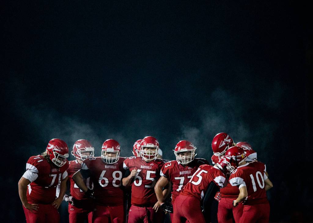 The Marysville Pilchuck offense huddles before the snap during the game on Oct. 5 in Marysville. (Olivia Vanni / The Herald)