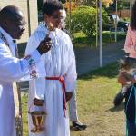 Father Stephen Okumu blesses a pet during a Blessing of the Pets celebration on Oct. 4 at St. Thomas More Parish School in Lynnwood. The celebration also included a pet food and toy drive. (Contributed photo)