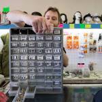 Shawn Winters, grandson of owners Jerry and Donna Winters, pulls out drawers of uniform insignias for a customer at Eds Surplus & Marine in Lynnwood on Wednesday. Eds is closing on Oct. 31 after 50 years in business. (Andy Bronson / The Herald)