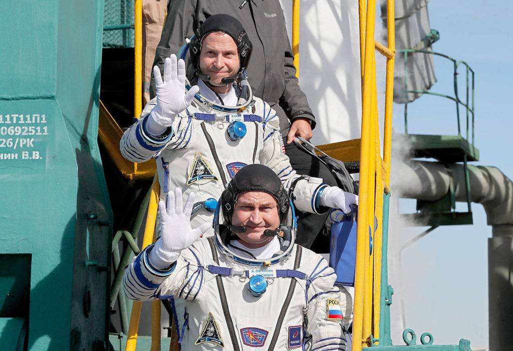 U.S. astronaut Nick Hague (top) and Russian cosmonaut Alexey Ovchinin, crew members of a mission to the International Space Station, wave as they board the rocket prior to the launch of a Soyuz-FG rocket at the Russian-leased Baikonur cosmodrome in Kazakhstan on Thursday. (Yuri Kochetkov, Pool Photo via AP)