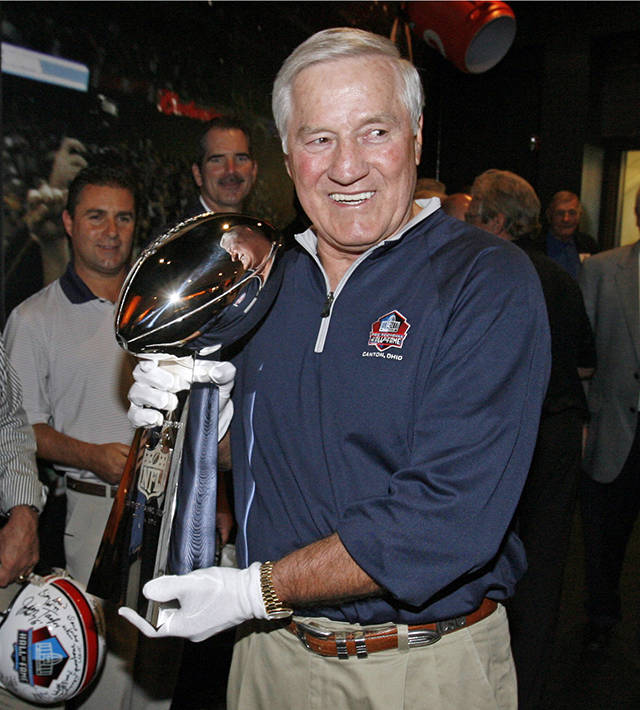 In this Sept. 28, 2009 photo, Hall of Famer Jim Taylor, from the Green Bay Packers, walks the Vince Lombardi Trophy through the Pro Football Hall of Fame after it was delivered by a Brinks armored car in Canton, Ohio. (Scott Heckel/The Canton Repository via AP, File)
