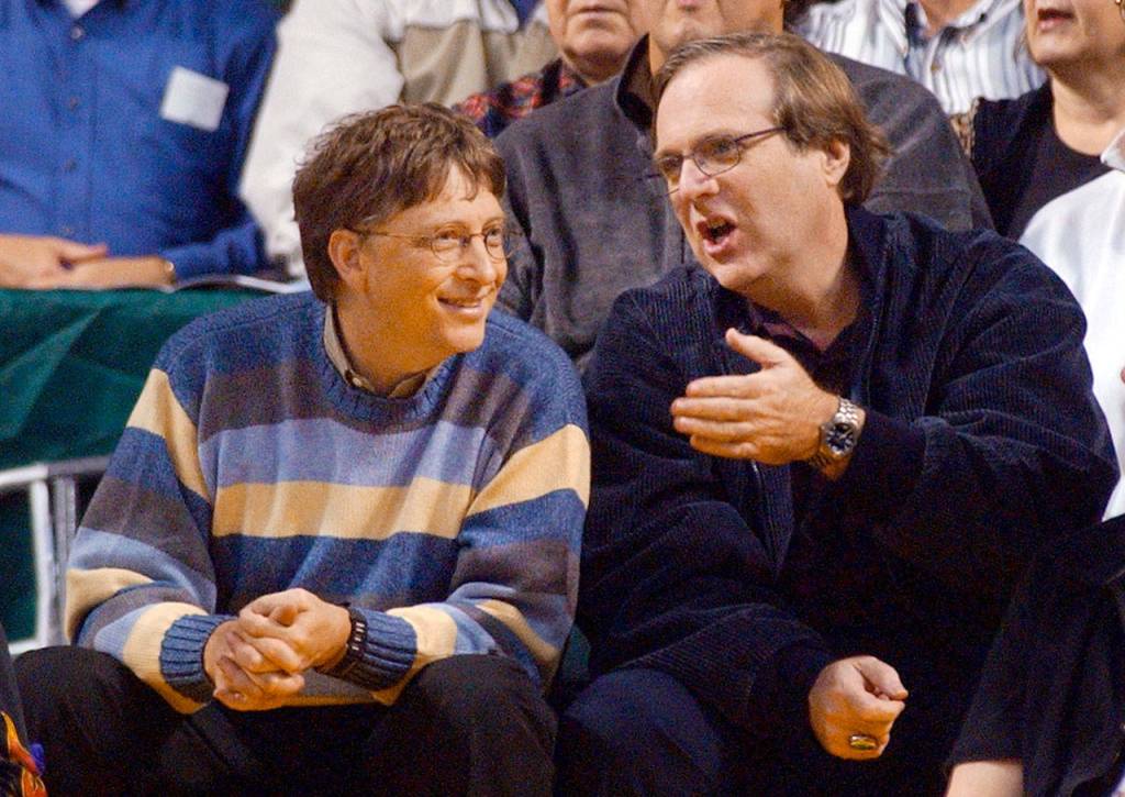 Bill Gates (left) chats with Portland Trail Blazers owner and former business partner Paul Allen during a game between the Trail Blazers and the Seattle SuperSonics in Seattle in 2003. (AP Photo/Elaine Thompson, File)
