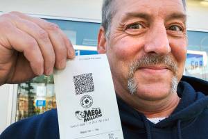 Jay Weaver of Everett holds tickets he bought Thursday at the Chevron station at Rucker Avenue and 41st Street.                                Somebodys got to win this. Why not me? he said. (Andrea Brown / The Herald)