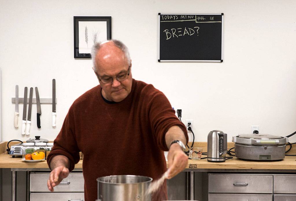 Bread is on the menu, as seen behind Andrew Ross from Oregon State University, who spreads out flour as he begins making bread at The Bread Lab. (Andy Bronson / The Herald)