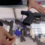 Gun shop owner Tiffany Teasdale demonstrates how a gun lock works on a handgun at her store in Lynnwood, Oct. 2. Voters in Washington state will decide the fate of an initiative that seeks to curb gun violence by toughening background checks for people buying semi-automatic rifles, increasing the age limit to 21 for buyers of those guns and requiring safe storage of all firearms. (Elaine Thompson/Associated Press)