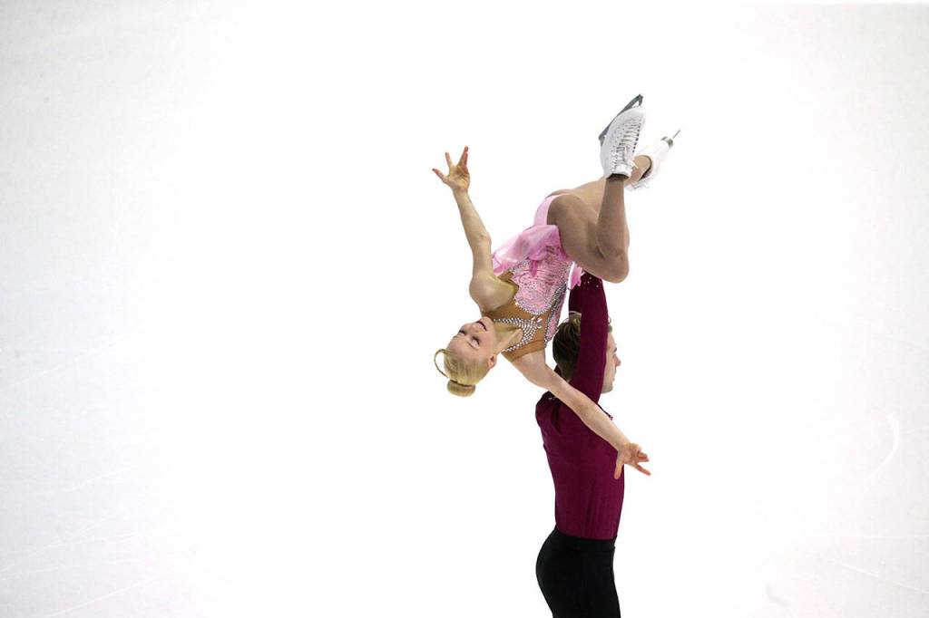 Nica Digerness is lifted by Danny Neudecker  who is based out of the Seattle Skating Club in Mountlake Terrace  during the pairs short program at the 2018 Skate America competition Friday at Angel of the Winds Arena in Everett. (Andy Bronson / The Herald)