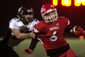 Marysville Pilchucks Dillon Kuk runs with Arlingtons Kristain Fairbanks attempting a tackle Friday at Quil Ceda Stadium in Marysville. (Kevin Clark / The Herald)