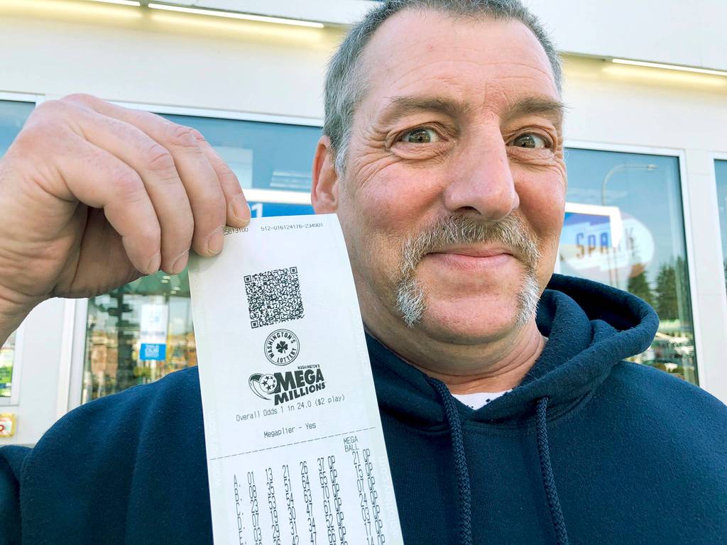 Jay Weaver of Everett holds tickets he bought at the Chevron station at Rucker Avenue and 41st Street. (Andrea Brown / The Herald)