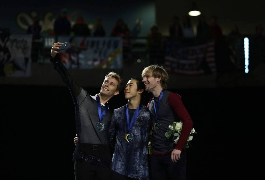 The medal winners of the men free skating program, Sergei Vornov, Nathan Chen and Michal Brezina, take a selfie on the podium at the 2018 Skate America competition on Saturday at Angel of the Winds Arena in Everett. (Olivia Vanni / The Herald)
