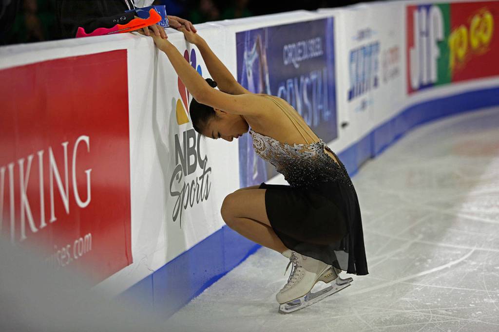 Kaori Sakamoto holds onto her coachs hands and takes a moment before the start of her ladies free skate program at the 2018 Skate America competition on Sunday at Angel of the Winds Arena in Everett. (Olivia Vanni / The Herald)