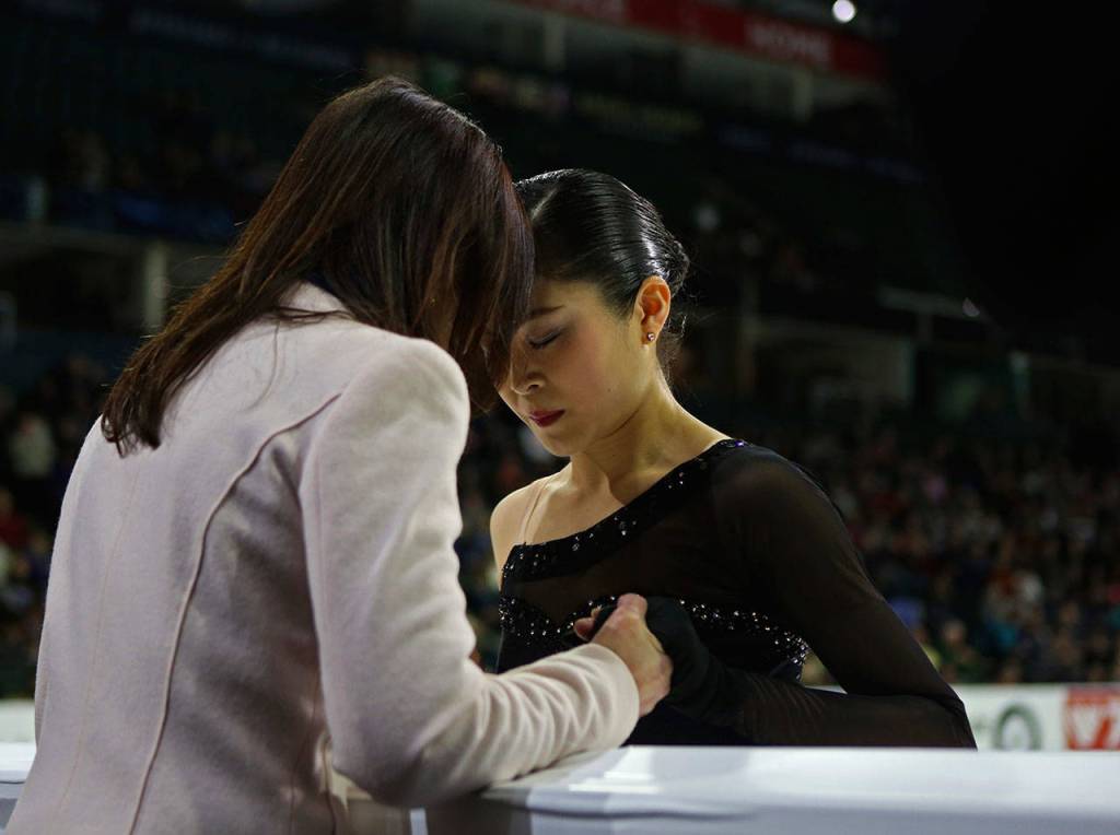 Satoko Miyahara closes her eyes before and touches foreheads with her coach before her ladies free skate program at the 2018 Skate America competition on Sunday at Angel of the Winds Arena in Everett. (Olivia Vanni / The Herald)