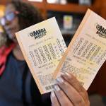 A shop employee in Atlanta holds Mega Millions lottery tickets on Monday. (AP Photo/Mike Stewart)